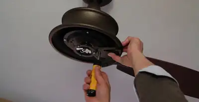 Electrician installing ceiling fan mounting bracket and fixture in Dayton, OH
