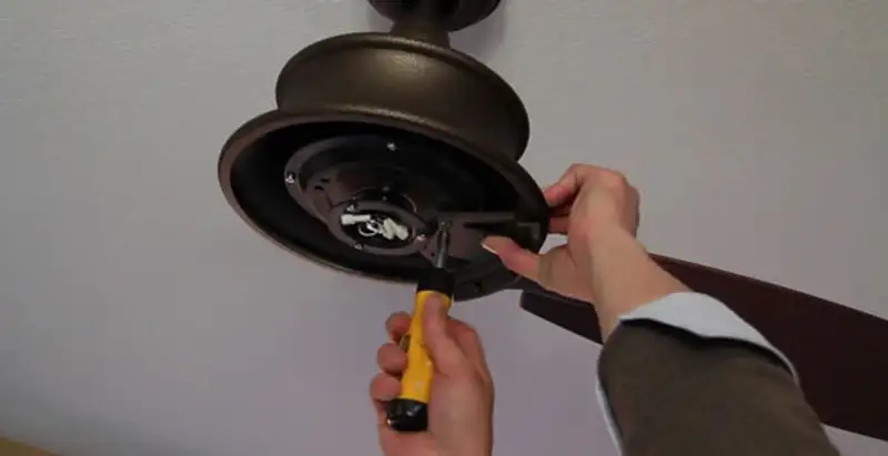 Electrician installing ceiling fan mounting bracket and fixture in Dayton, OH
