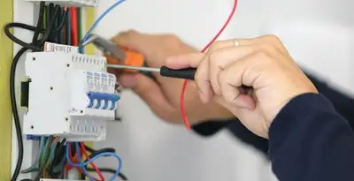Electrician installing and adjusting circuit breakers in an electrical panel in Dayton, OH