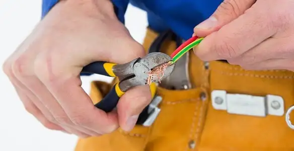 licensed electrician securing electrical wiring with professional tools during service work in Dayton, OH