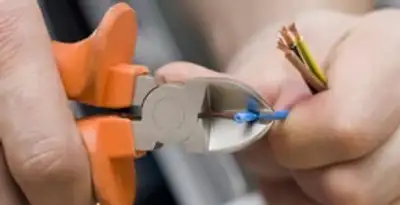 licensed electrician performing precise wire cutting and preparation during electrical service in Dayton, OH