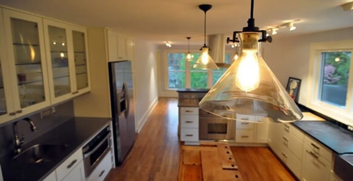 Residential electrician installing modern indoor light fixture in a home in Dayton, OH