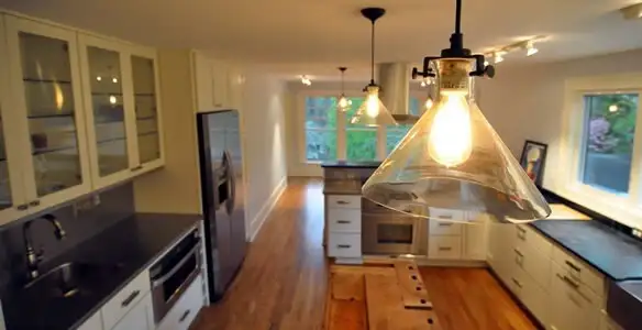 Residential electrician installing modern indoor light fixture in a home in Dayton, OH