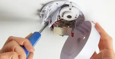 Certified technician wiring smoke detector during installation in Dayton, OH